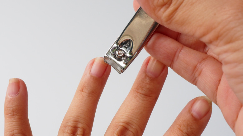 Woman trimming her fingernails