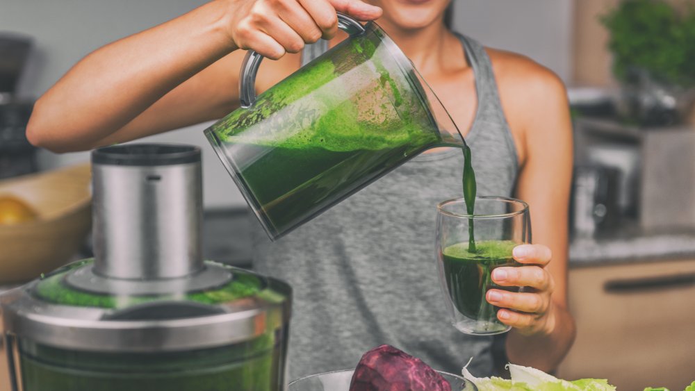 woman pouring green juice