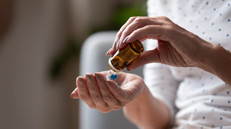 Woman pouring supplements into her hand