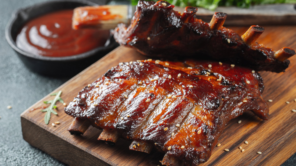 Grilled spare ribs with sauce placed on a wooden cutting board