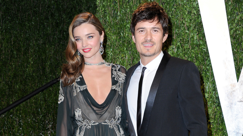 Orlando Bloom in skinny black tie and Miranda Kerr smiling together