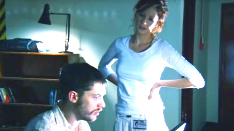 Kelly Reilly in white shirt and pants with hands on hips in A for Andromeda