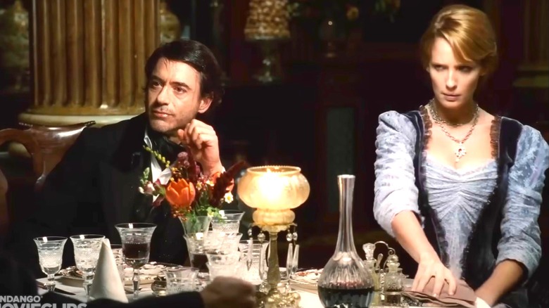 Kelly Reilly sitting at a table in period costume with Robert Downey Jr. in Sherlock Holmes
