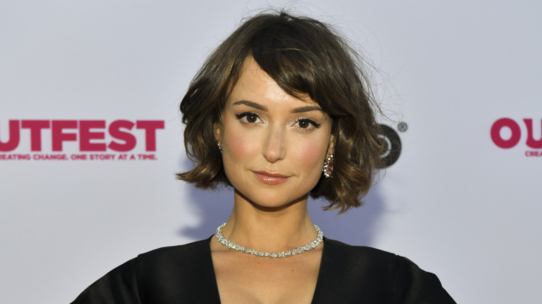 Milana Vayntrub posando en una alfombra roja