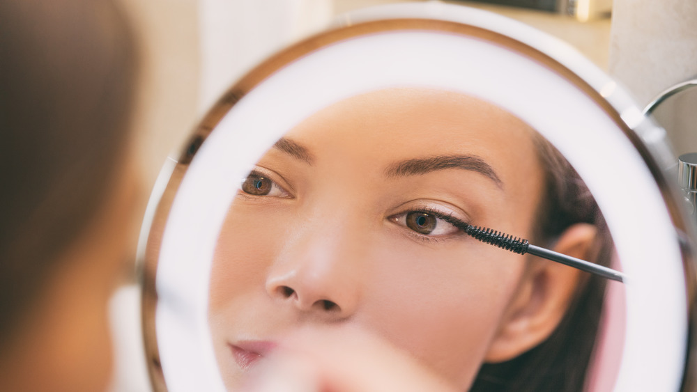 Woman applying product to her eyelashes