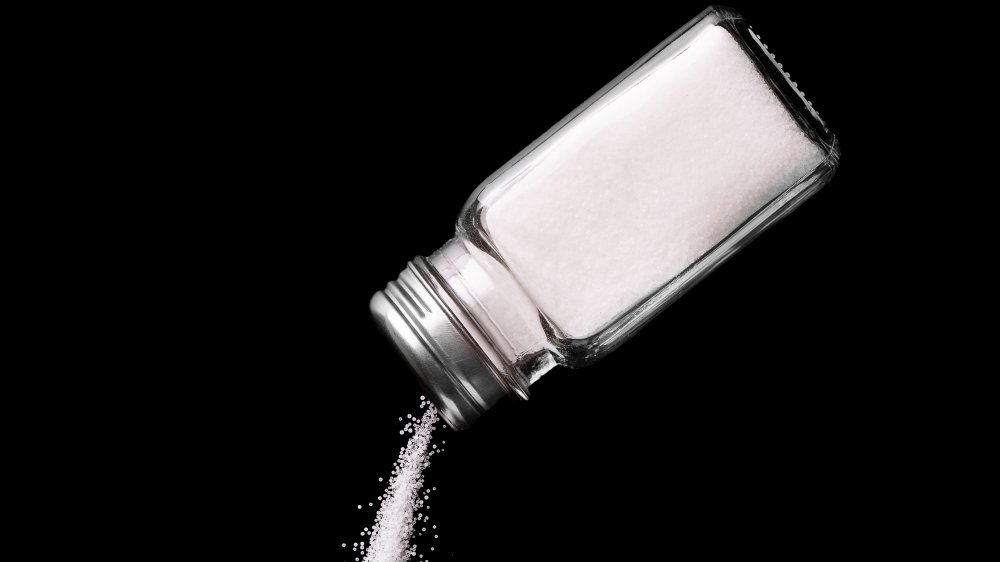 Spilling salt, all black background 