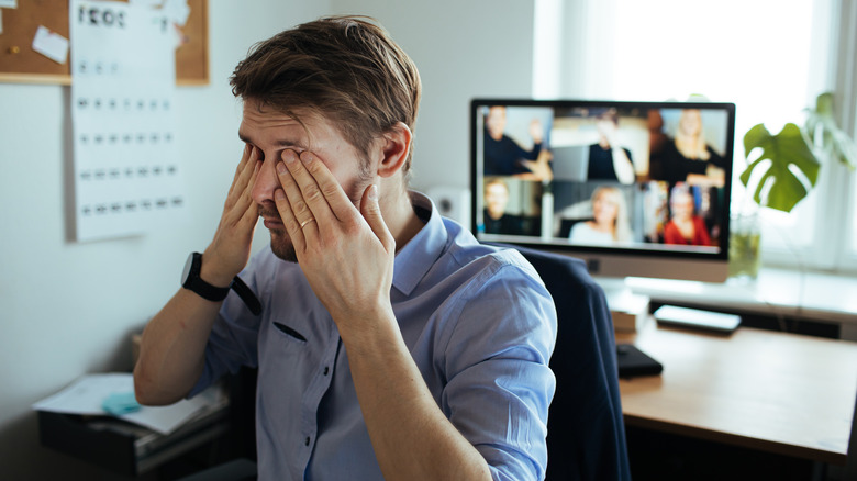 Man covering his eyes