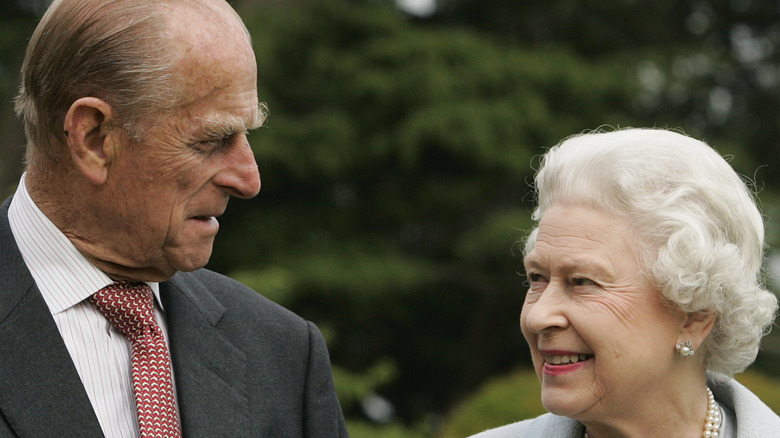 Queen Elizabeth and Prince Philip looking at one another
