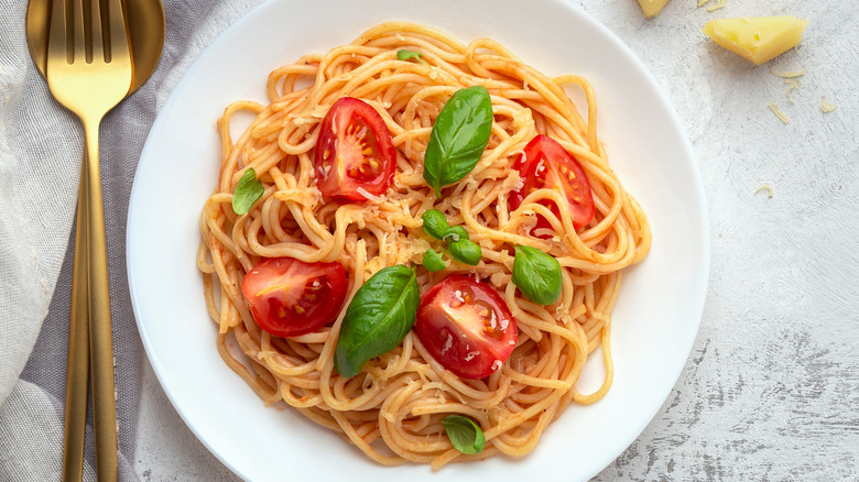 A plate of pasta topped with tomatoes