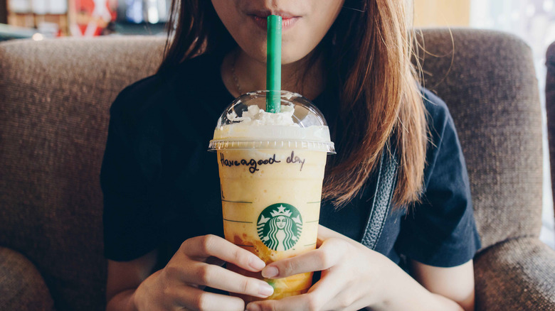 Woman drinking orange Frappuccino