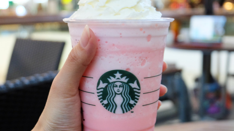 Hand holding pink Starbucks drink