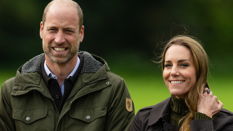 A smiling Prince William and Princess Catherine in complementary green and brown outfits