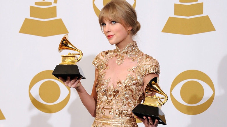 Taylor Swift holding her Grammy trophies in 2012