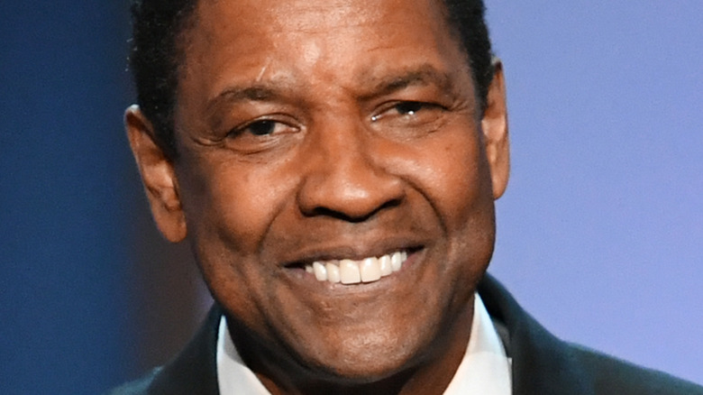 Denzel Washington smiles onstage at an event