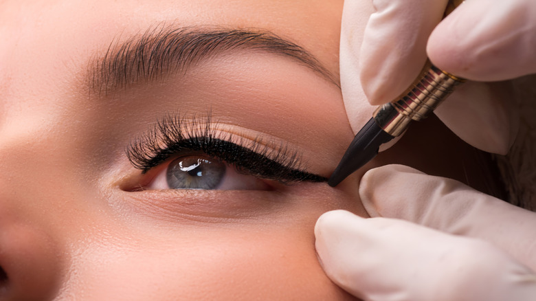 Woman getting cat eye eyeliner applied