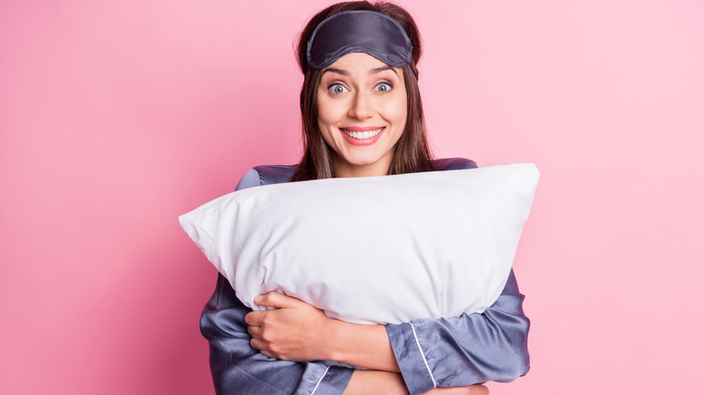 Woman hugging a pillow and smiling