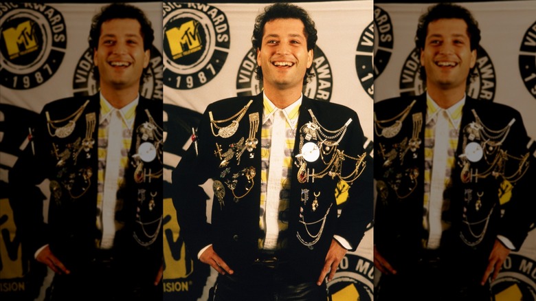 Howie Mandel wearing a black jacket covered with gold brooches and chains at the 1987 MTV Video Music Awards.