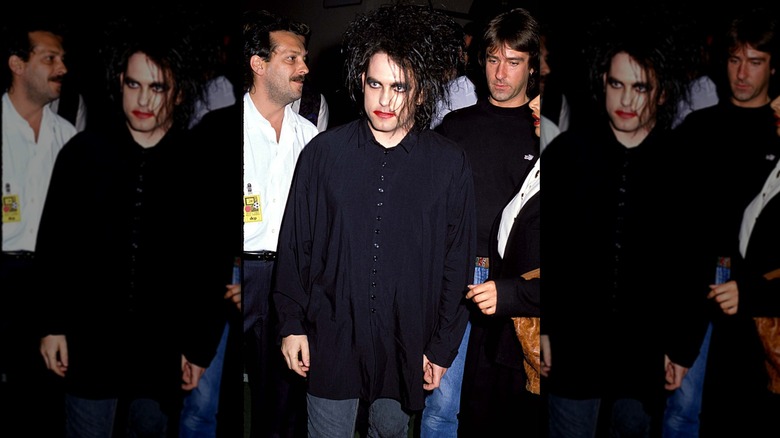 Robert Smith wearing a baggy black shirt and smeared red lipstick at the 1989 VMAs.