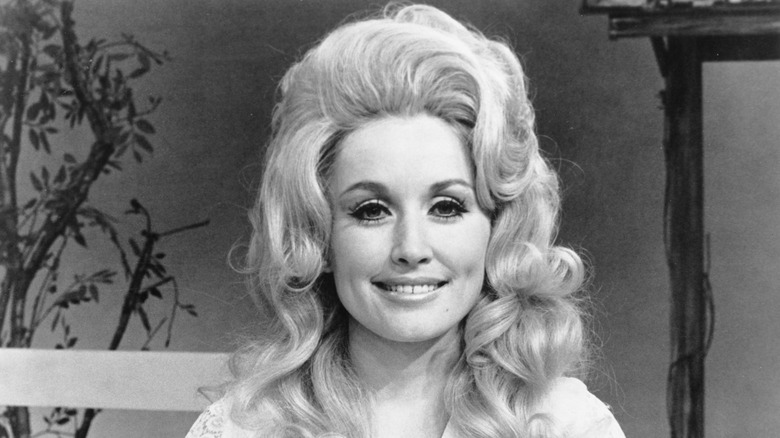Dolly Parton with a graphic liner look and big curls