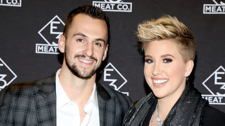 Savannah Chrisley smiling while posing at an event with Nic Kerdiles