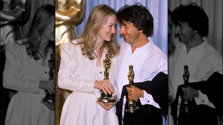 Meryl Streep and Dustin Hoffman smiling while holding their Oscars statuettes at the 1979 Academy Awards