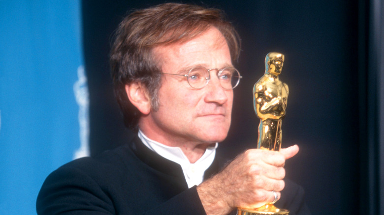Robin Williams holding up an Academy Award