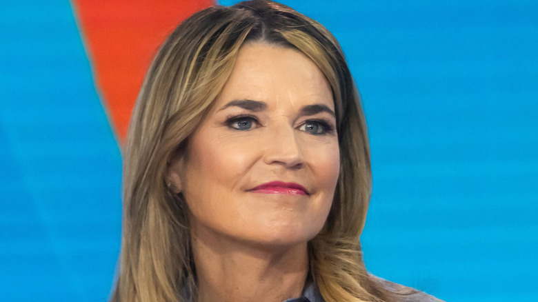Savannah Guthrie in front of a light blue background with her mouth closed