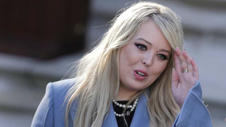 Tiffany Trump pushing her hair out of her face in a blue blazer