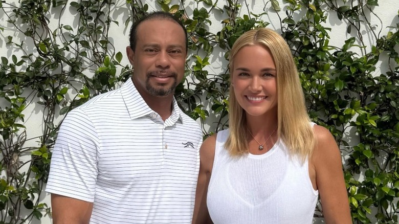 Tiger Woods and Vanessa Woods pose together in front of some vines