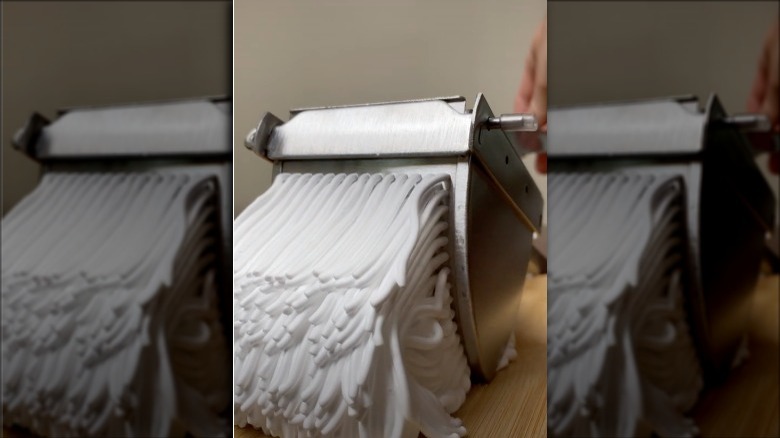 Screenshot from oddly satisfying TikTok shaving cream video with foam being pushed through a garlic press.