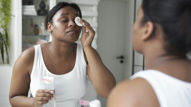 Woman uses micellar water on face