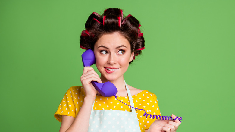 A woman with hot rollers talking on the phone
