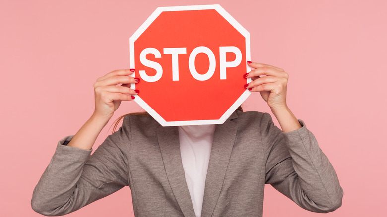 Person stop sign in front of face