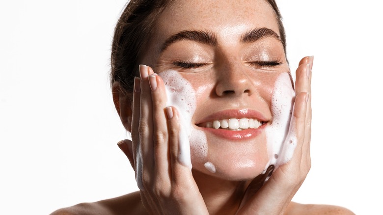 Woman washing her face with cleanser