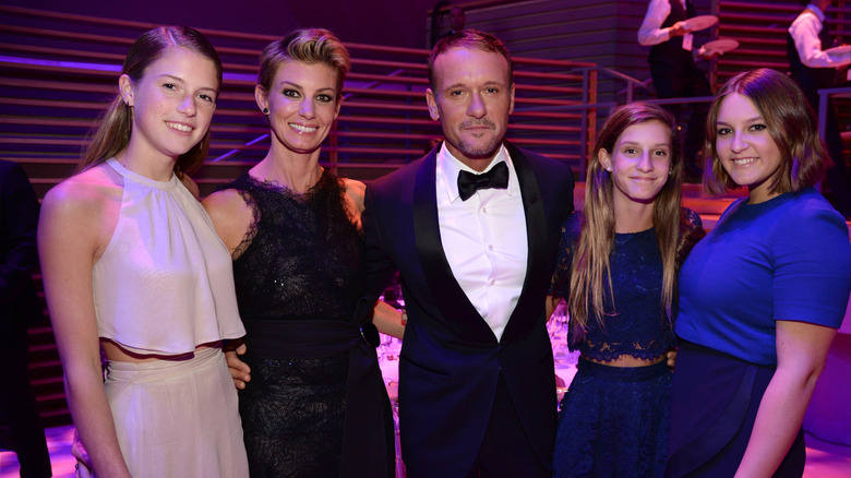 Tim McGraw and Faith Hill posing with their daughters