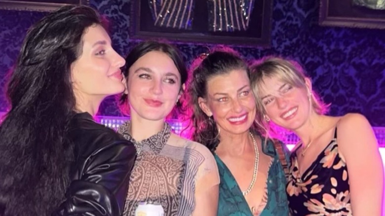 Faith Hill smiling with her three daughters at a bar