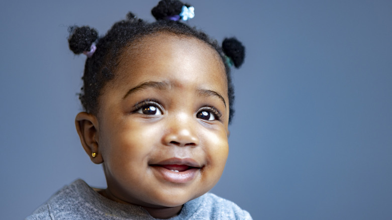 Baby smiling against a blue background