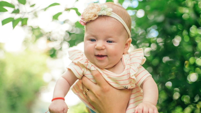 Baby smiling while being held in the air