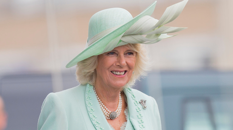 Queen Camilla smiling in green outfit