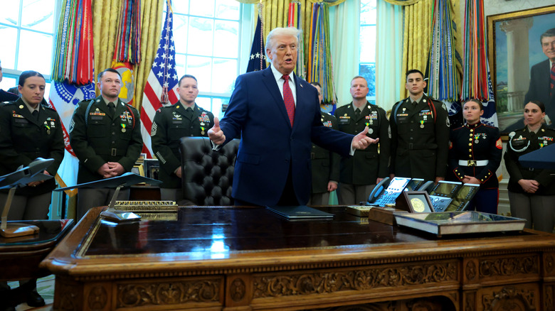 Donald Trump standing behind the Resolute Desk in the Oval Office