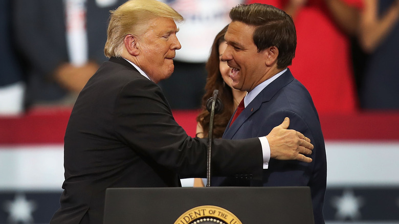 Donald Trump patting Ron DeSantis on the shoulder