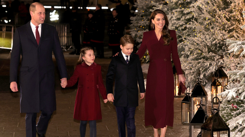 The Wales family next to Christmas trees