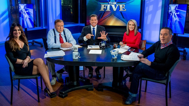Kimberly Guilfoyle sitting down smiling while next to 'The Five' hosts.