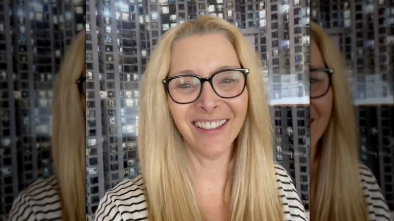 Lisa Kudrow smiles in a white-and-black striped shirt