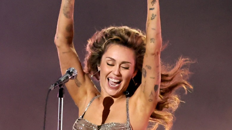 Miley Cyrus performing, smiling