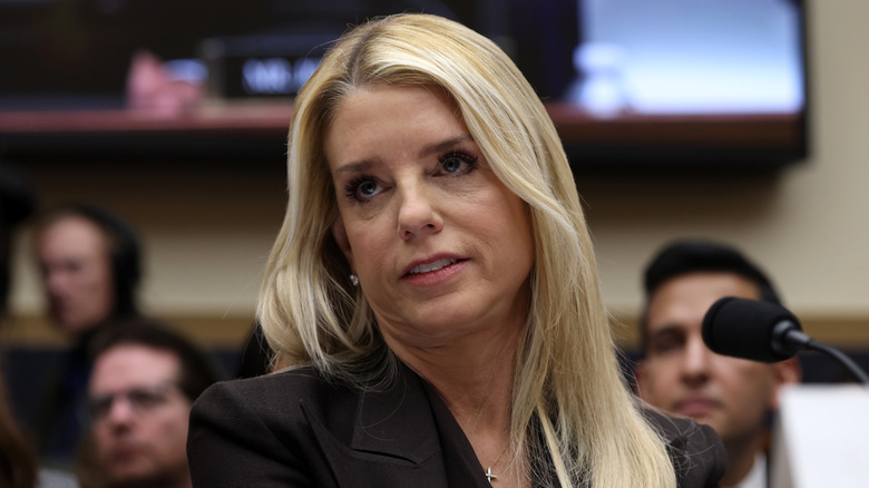 Pam Bondi wears a cross necklace and looks annoyed during a hearing on the Epstein files.