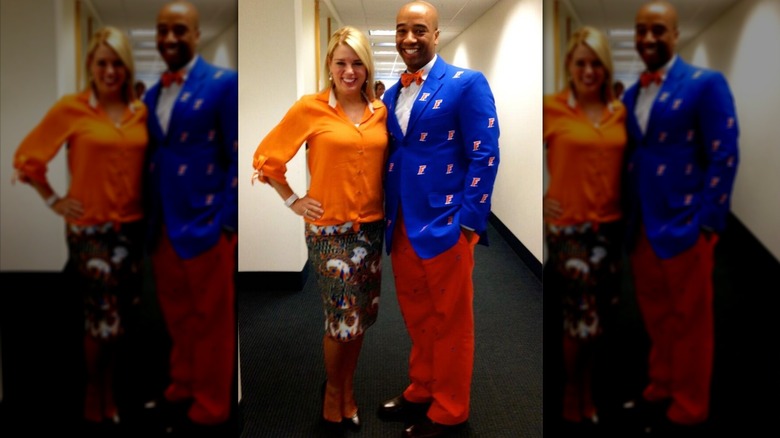 Pam Bondi wears an orange tied-up top and patterned pencil skirt while posing next to Jamal Sowell.