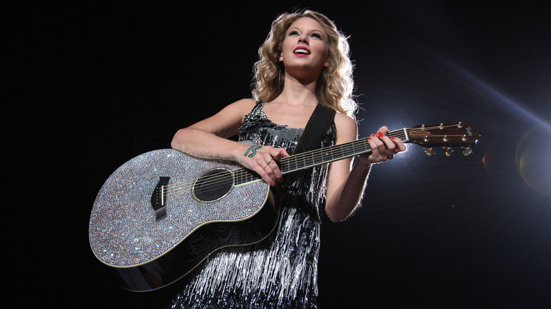 Taylor Swift performing with a guitar during her Fearless Tour in 2009