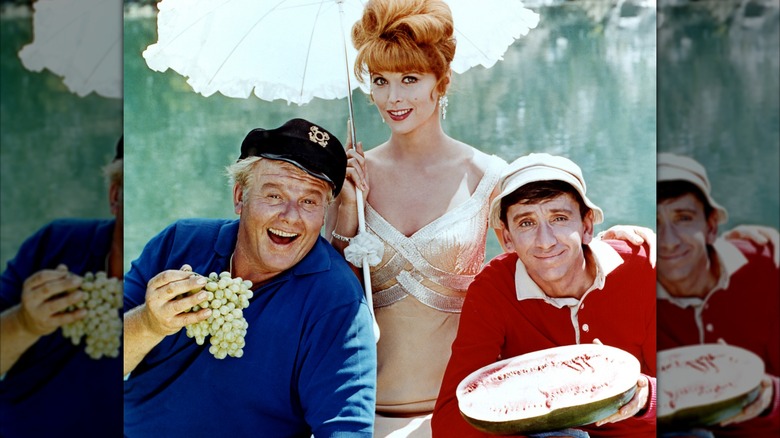 Alan Hale Jr., Bob Denver, and Tina Louise smiling in a "Gilligan's Island" portrait