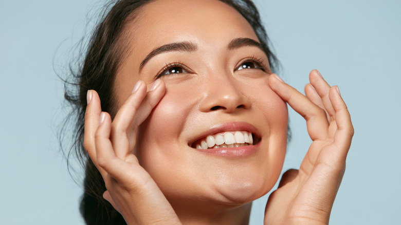 Woman smiling touching cheeks